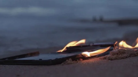 Burning data disc on the sand at coast Stock Footage 74364198