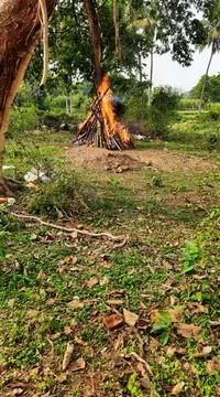 Burning dead body outside the empty space of village, its indian tradition an Stock Photos