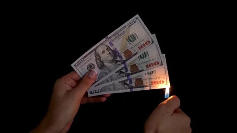 Burning dollars in a hand close-up on a black background Stock Footage 83296174