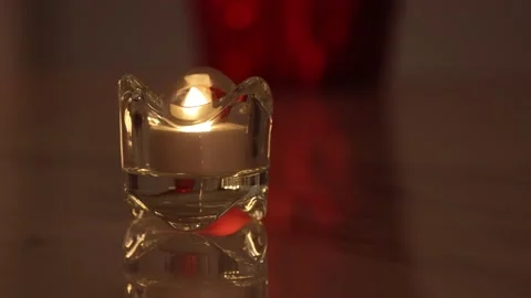 Burning e-candle in a crystal candle holder with red background Stock Footage 146554388