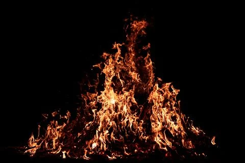 Burning embers beneath bright fire. Embers glowing beneath bonfire flames. Gl Stock Photos