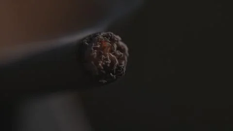 Burning end of a cigarette macro background Foto stock