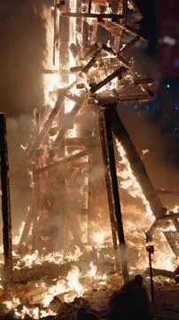 Burning falla wooden structure collapsing in flame during crema ceremony Stock Photos