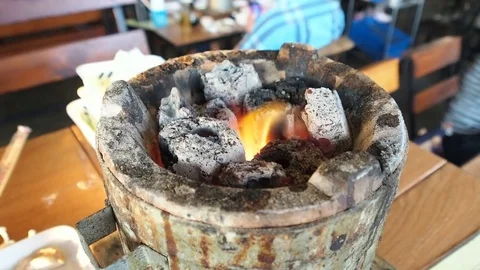 Burning fire and bright coals in stove on the table at thai bbq restaurant. 스톡 동영상 83905364