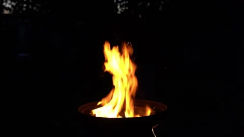 A burning fire in the barbecue at night. Correcting coals with a poker Stock Footage 283649218