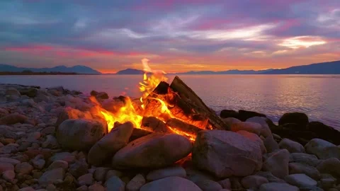 Burning fire on the beach at the lake. Mountain, Sunset, Sunrise. 4K Stock Footage