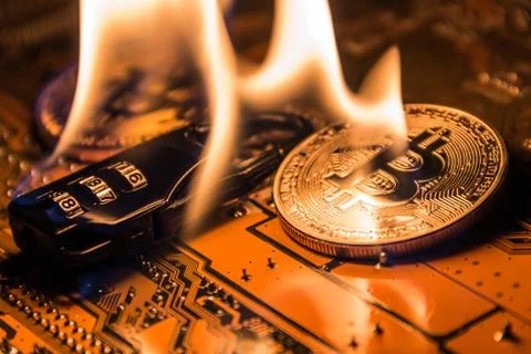 The burning fire on the code lock between the gold and silver bitcoins on the Foto stock