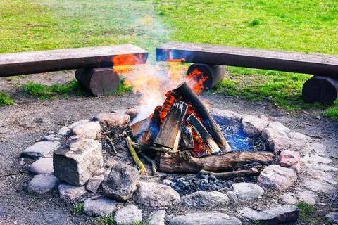 A burning fire in the hearth against a background of wooden benches and gre.. Stock Photos