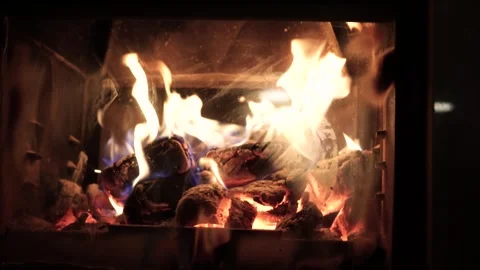 Burning fire logs inside stone fireplace. Close-up view. Stockbeeldmateriaal 282675014