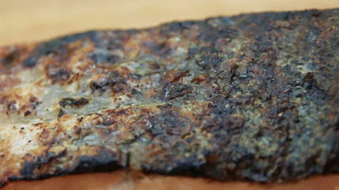 Burning fire pieces of fish lying on a plate Video stock 154924024