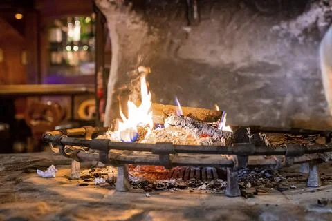 Burning fire place in rustic restaurant during winter Stock Photos