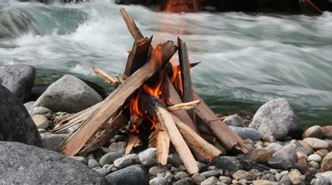 Burning a fire on the shore of a mountain river Video stock 61103220