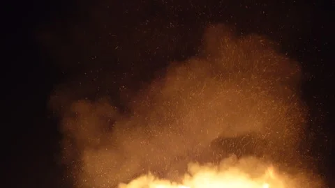 Burning fire with trails of embers floating up into the dark sky 動画素材 333983896