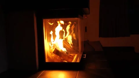 Burning fireplace in a dark room. Heating the house with a fireplace. Stock Footage 254711730