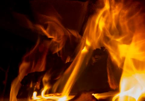 Burning fireplace, firewood, evening warmth and comfort Stock Photos