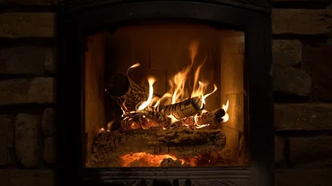 Burning fireplace with wooden logs and flame inside. Warm light, romantic Stock Footage