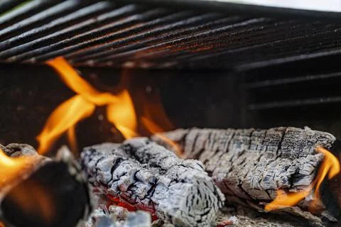 Burning firewood with flame through bbq grill grates Stock Photos