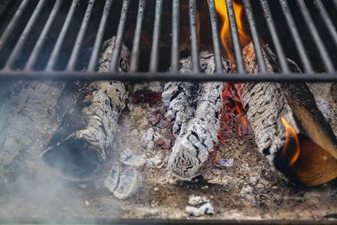 Burning firewood with flame through bbq grill grates Stock Photos