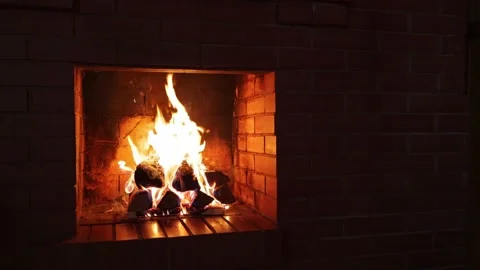 Burning firewood in a red brick fireplace in a country cottage in dark cold nigh Stock Footage 163987791