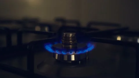 Burning flame of gas, blue fire on kitchen stove with stack of coins Stock Footage 206390800
