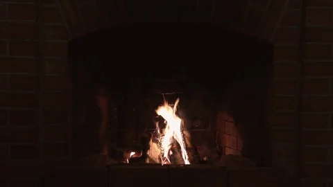 Burning flame in a red brick fireplace in a country house in the evening Stock Footage 123705315