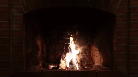 Burning flame in a red brick fireplace in a country house in the evening Stock Footage 123705554