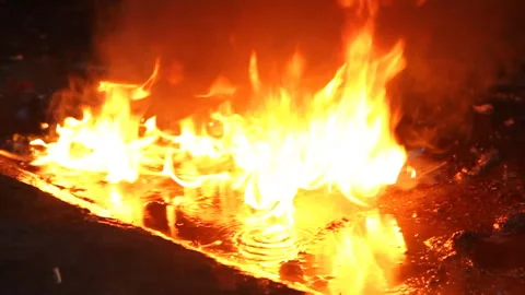 Burning fuel on the ground in the rain Stock Footage 94281481
