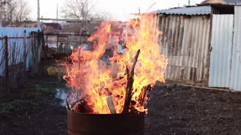 Burning garbage and dry branches in a large tank. Strong bonfire, fire. Stock Footage 153511287