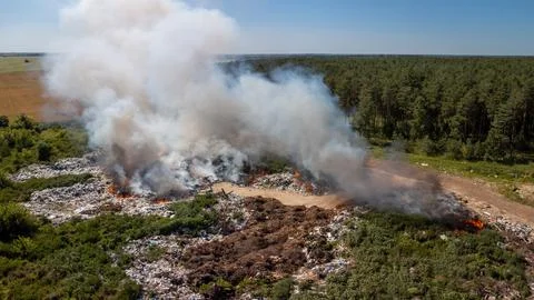 Burning garbage heap on a dumpsite Stock Photos