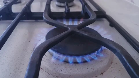 Burning gas with a blue flame on the burner of a kitchen gas stove Stock Footage 182555973