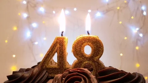 Burning gold candles in the shape of the number 48 on a birthday cake Stock Footage 105447559