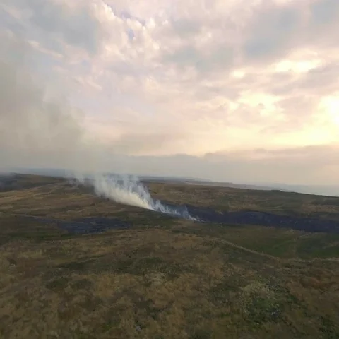 Burning grass fields in the hills, UK, England. Aerial view Video stock 69518434