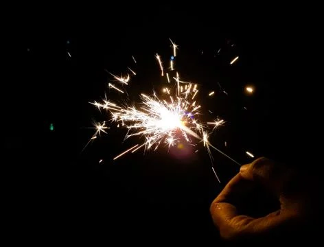 Burning of hand held sparkle firework in black background Stock Photos