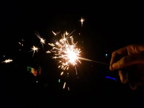 Burning of hand held sparkle firework in black background Stock Photos