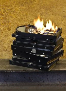 Burning hard disks burning stack of hard disks in front of rusty back Copy... Foto stock
