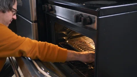 Burning His Hand on a Too Hot Oven Stove Stock Footage 102864560