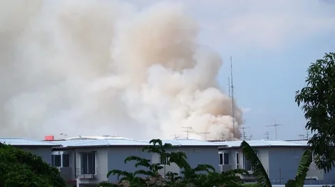 Burning house causes a big pile of smoke, black smoke rising up to blue sky Stock Footage 54077331