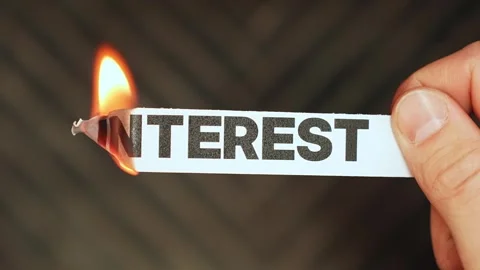 Burning “interest” label held by hand, symbolizing lower rates, debt relief Stock Footage 333651967