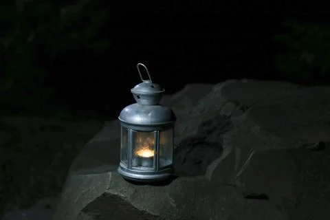 Burning lantern on a stone in the moonlight Stock Photos