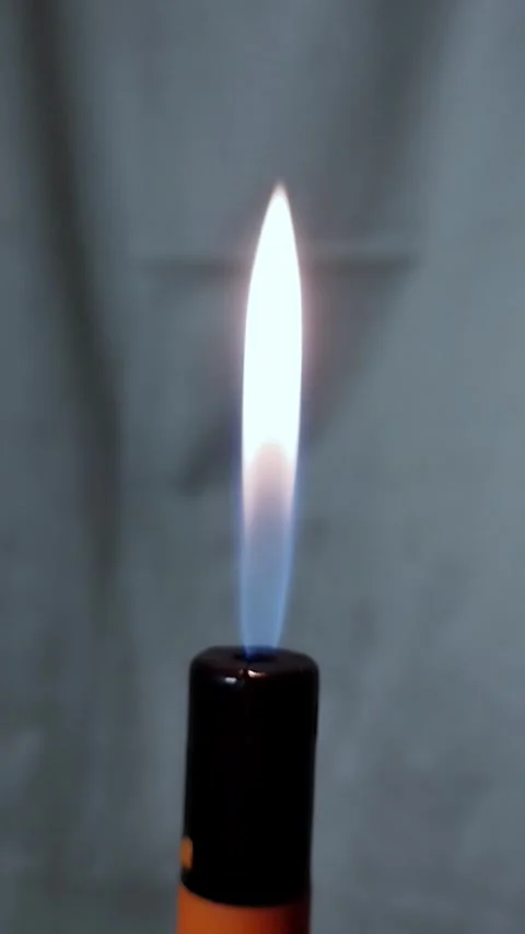 A burning lighter on a gray canvas background. Stock vertical video with fire in Stock Footage 292750861