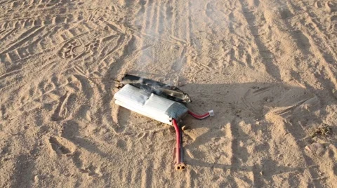 Burning lithium-polymer battery on sand outdoor with smoke Stock-Footage 52783063
