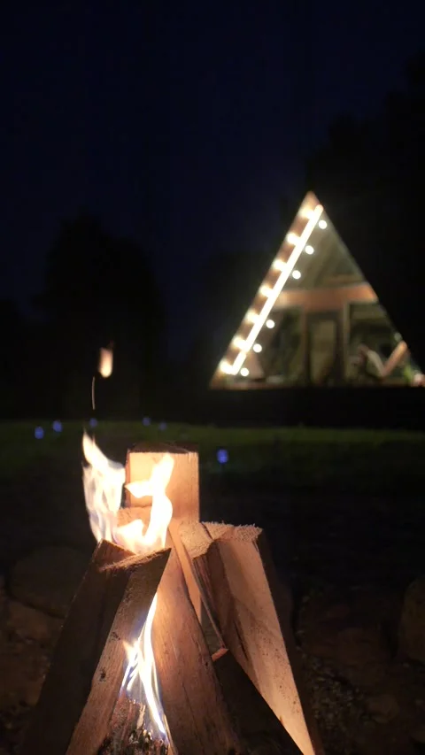 Burning logs against a background of A-frame house located in the forest. Stock Footage 311048608