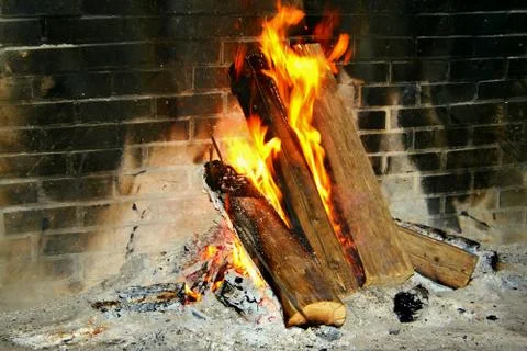 Burning logs in a brick fireplace Stock Photos