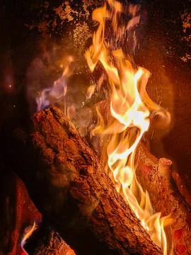 Burning logs creating warm fire flames with sparks Stock Photos