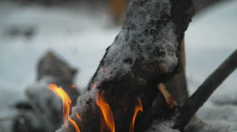 Burning logs in fire pit outside with snow background. Slow Motion. Stock Footage 50503072