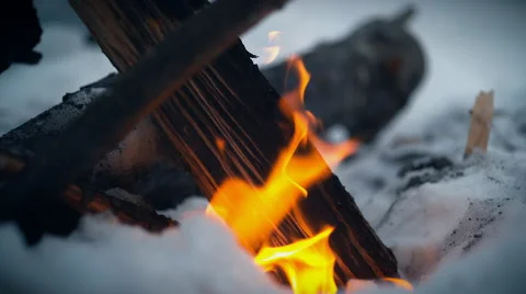 Burning logs in fire pit outside with snow background. Slow Motion. Stock Footage 50503208