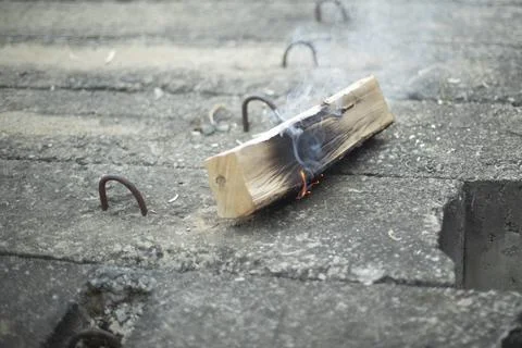 Burning logs. Set fire to the logs. Child playing with fire. Stock Photos