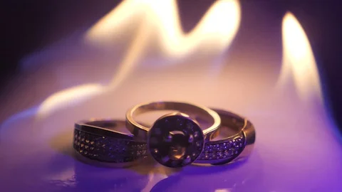 Burning macro wedding rings lay on the white surface Stock Footage 129004112