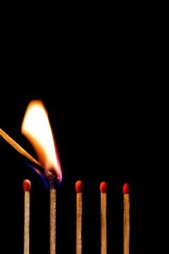 Burning match on black background Stock Photos