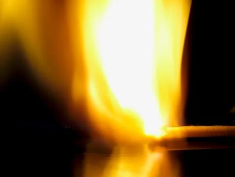 Burning match on a black background. Stockfoto's